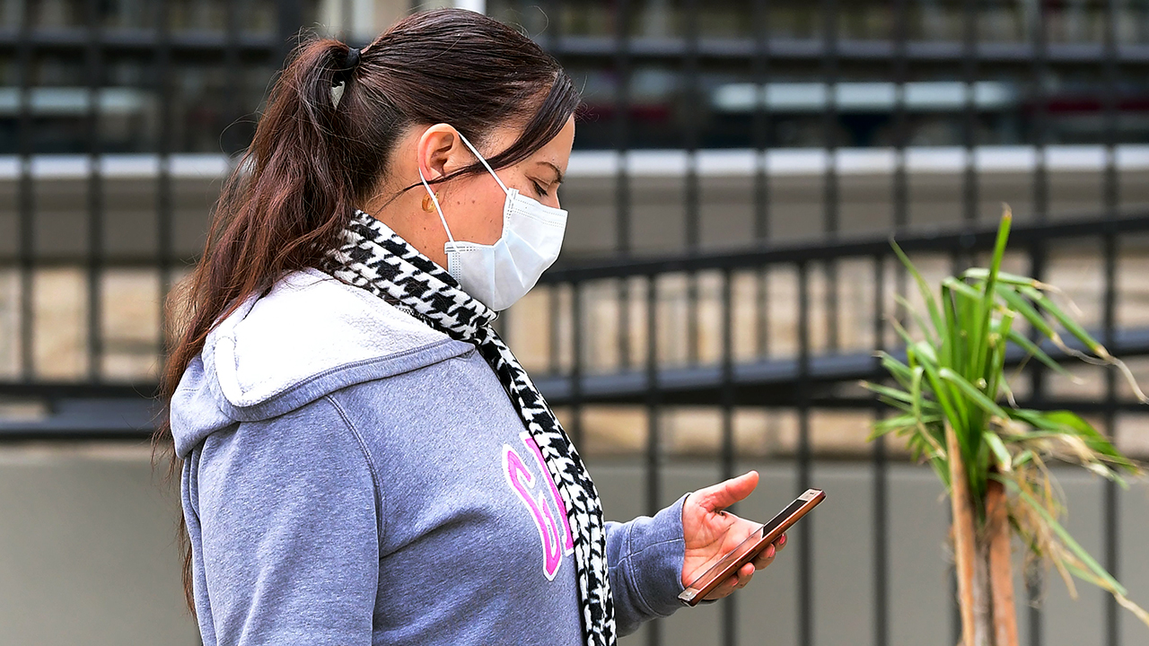 A woman checks her cellphone in Los Angeles on March 20. Los Angeles County had announced a near-lockdown a day earlier in an effort to slow the spread of the coronavirus. (Frederic J. Brown/AFP via Getty Images)